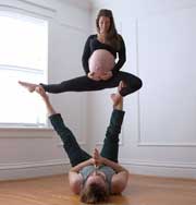 Беременная женщина с мужем исполняют його-акробатические этюды. Фото